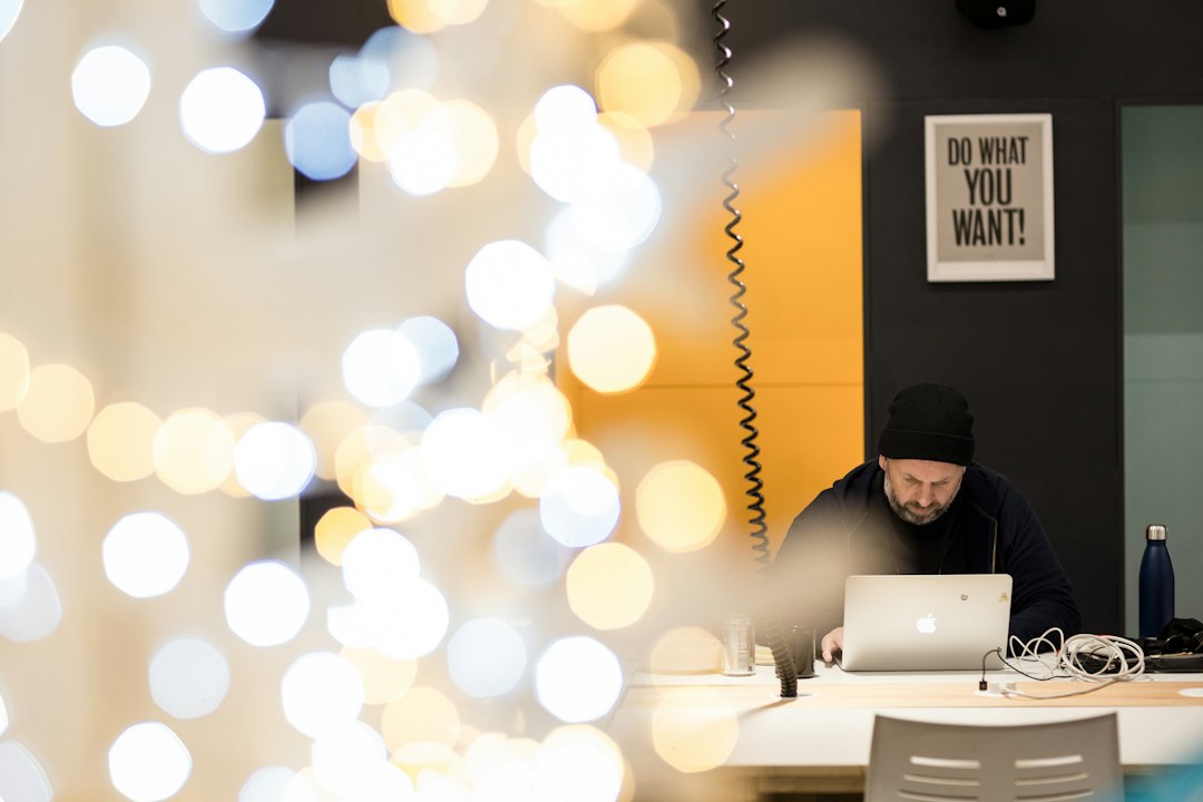 a man sitting at a table working on a laptop